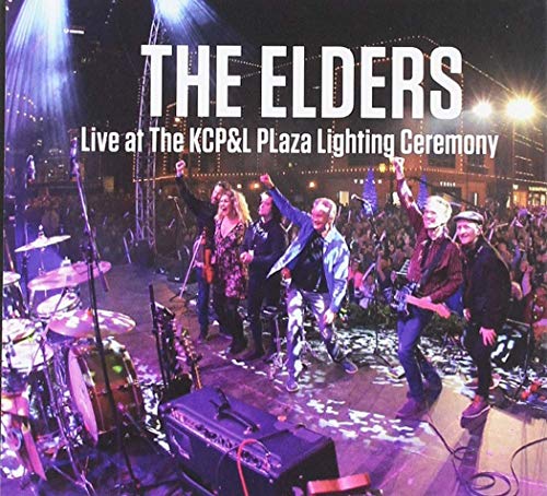 The Elders band performing live on stage at a brightly lit plaza.