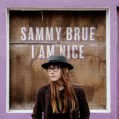 Album cover featuring a man in a hat and glasses before a purple wall.