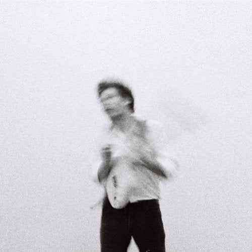 Blurred black and white portrait of a person in light clothing.