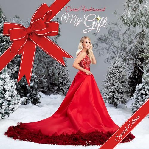 Carrie Underwood in a red gown stands in a snowy, winter landscape.