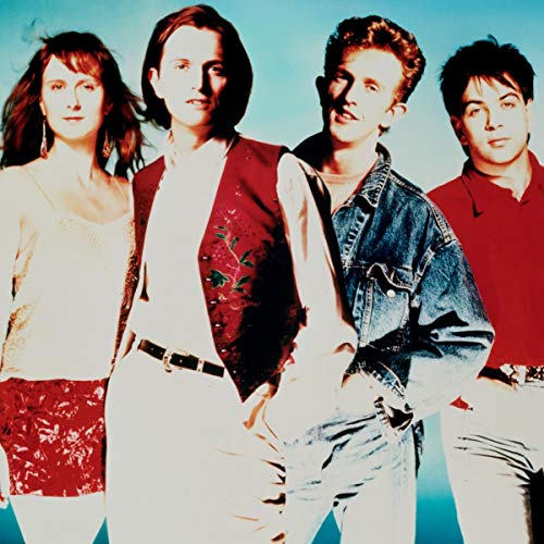 Four band members stand side-by-side against a light blue background.