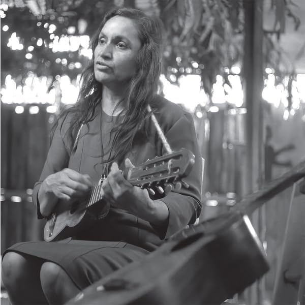Violeta Parra playing a small guitar, black and white portrait.