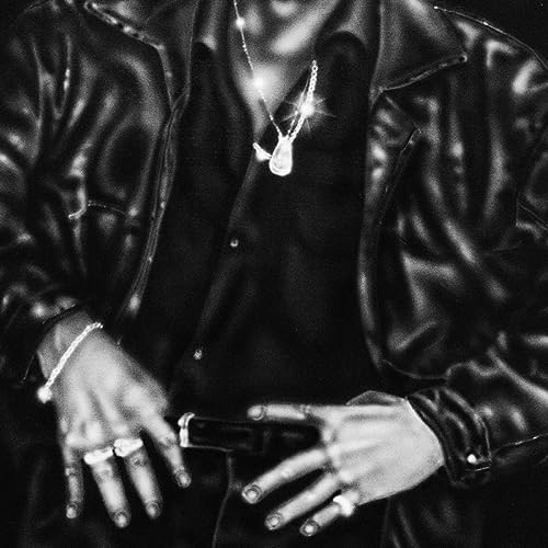 Black and white portrait of Tony Price wearing a leather jacket and jewelry.