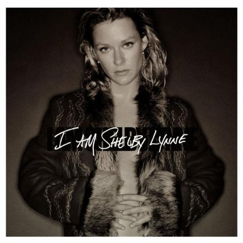 Black and white portrait of Shelby Lynne in a fur-collared coat.
