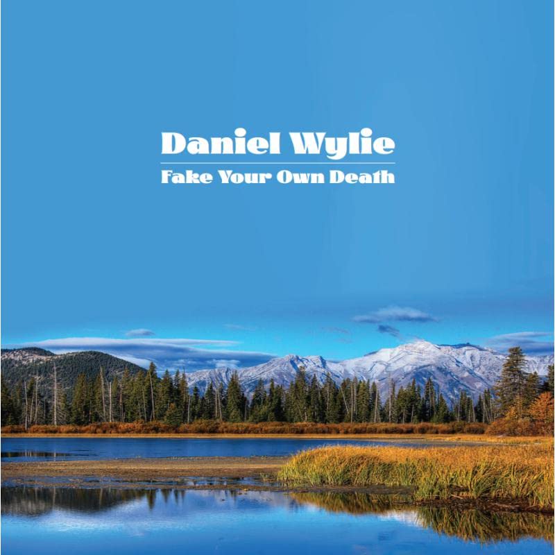 Album cover: mountains, trees, and water with text "Daniel Wylie - Fake Your Own Death".