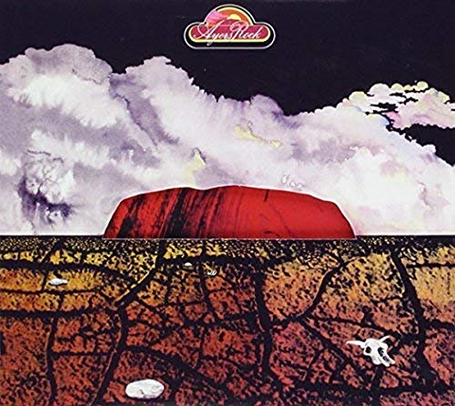 Album cover depicting a large red rock formation under cloudy skies.