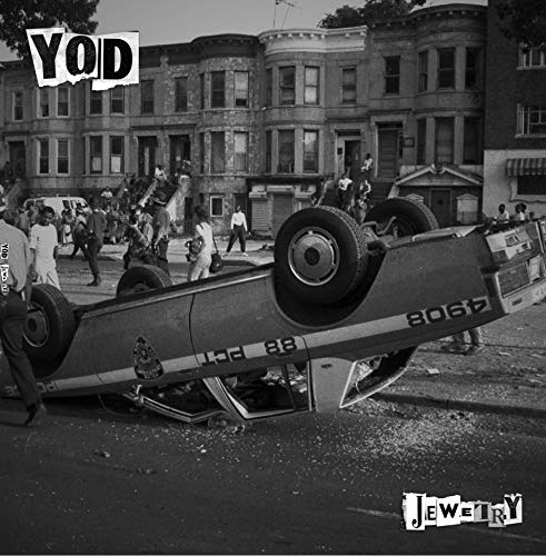 Black and white album cover featuring a crashed car in a city street.