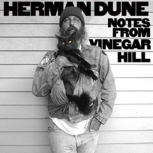 Black and white album cover featuring a man holding a black cat.