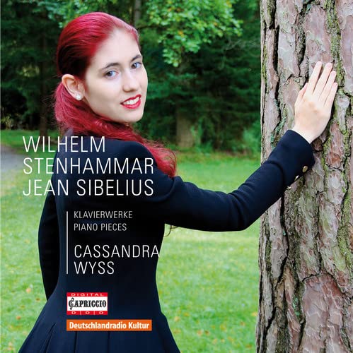 Red-haired pianist Cassandra Wyss poses beside a tree on CD cover.