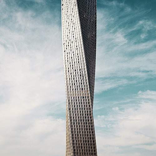 Tall, twisting modern building against a blue, cloudy sky.