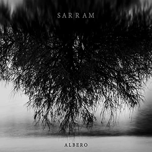 Black and white album cover with tree roots reflected in water.