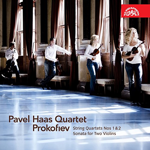 String quartet performing in a bright, airy room with large windows.