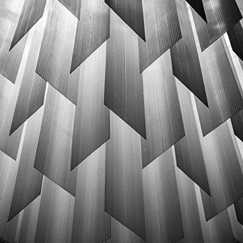 Black and white abstract pattern of angled, repeating geometric shapes.