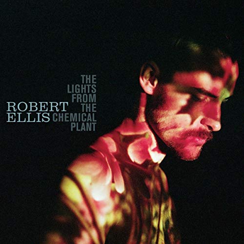Record album cover featuring a man’s face with colored light projections.