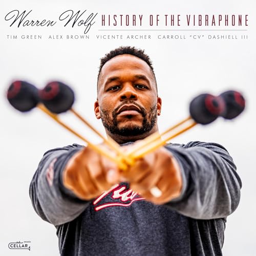 Warren Wolf holding vibraphone mallets, album cover for "History of the Vibraphone".