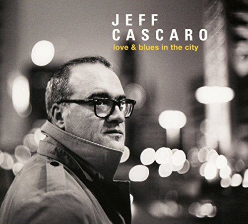 Black and white portrait of Jeff Cascaro with blurred city lights.