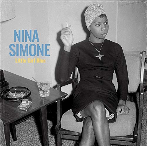 Nina Simone in a headwrap, seated with a cigarette and drink.