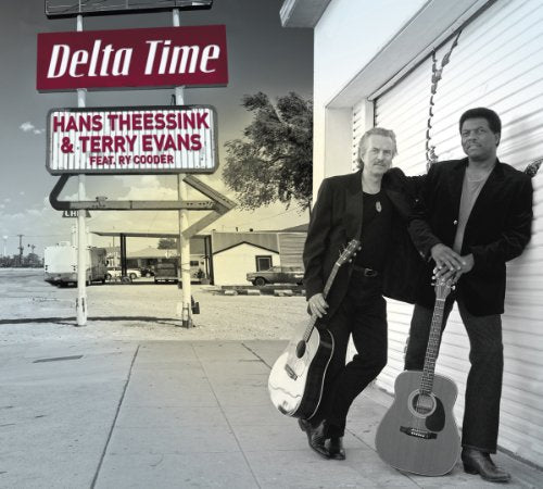 Two musicians with guitars lean against a building near a vintage sign.