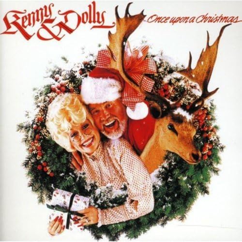 Kenny Rogers and Dolly Parton smiling with reindeer and Christmas greenery.