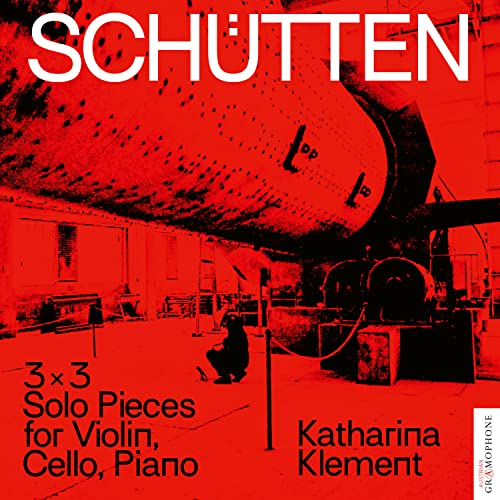 Red album cover with a blurred industrial scene and musical notation.