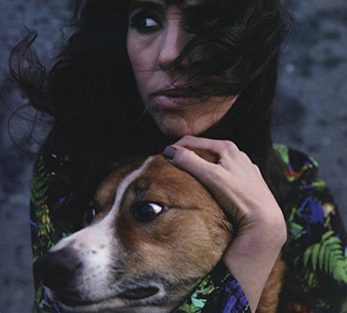 Woman with dark hair embraces a brown dog, close-up portrait.