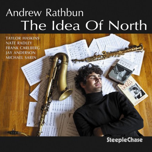 CD cover: man with saxophones and sheet music on wooden floor.