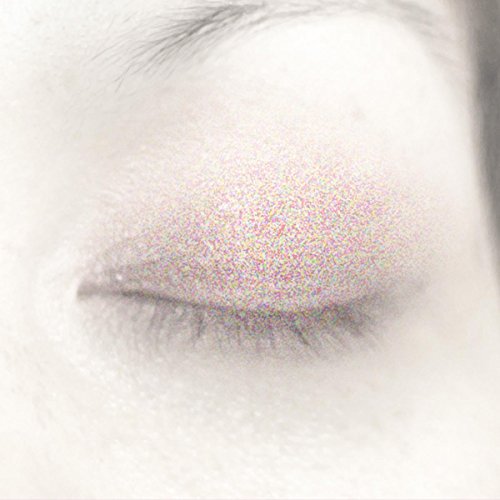Close-up of a closed eye with a colorful, speckled texture.