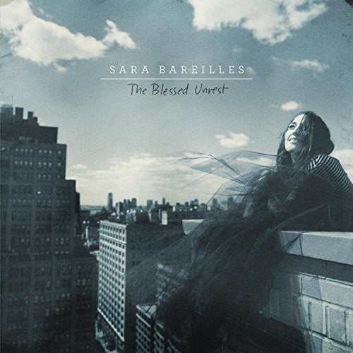 Sara Bareilles album cover, cityscape backdrop, woman looking upwards.