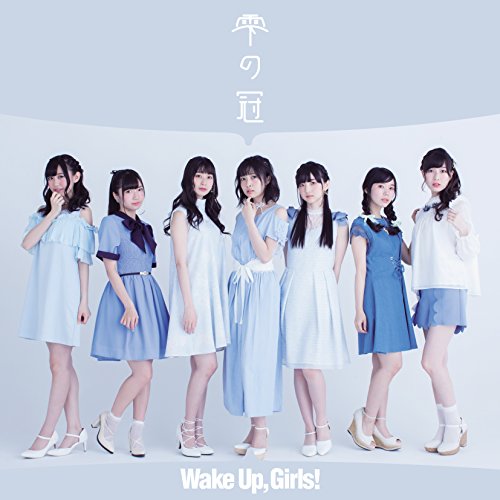 Seven young women in blue and white dresses standing against a light blue background.