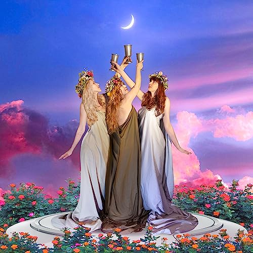 Three women in white gowns with flower crowns raise golden cups.