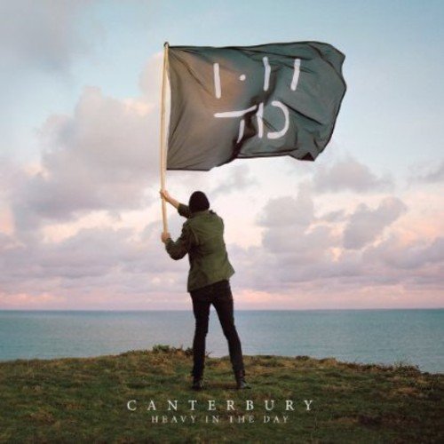 Person holding a waving flag overlooking the sea, album cover.