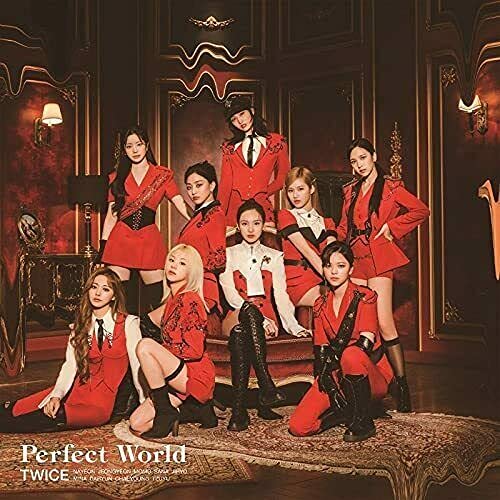 Nine women in red and white outfits pose in a baroque-style room.