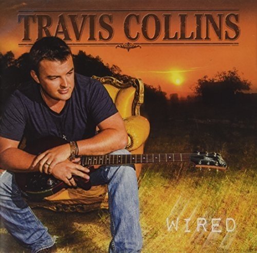 Travis Collins sits with a guitar before a sunset landscape.