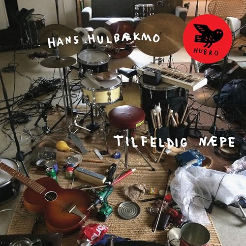 CD cover with musical instruments, cans, and a red stool on a rug.