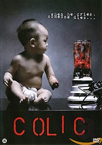 A baby in a diaper sits next to a blender filled with red liquid.