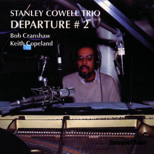 Stanley Cowell at a piano with headphones in a recording studio.