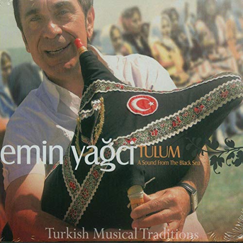 Man holding a decorated tulum (bagpipe) with a Turkish flag detail.