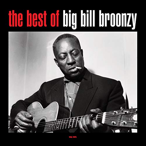 Black and white portrait of Big Bill Broonzy playing an acoustic guitar.