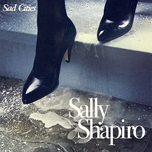 Black ankle boots stepping in a puddle, album cover art.