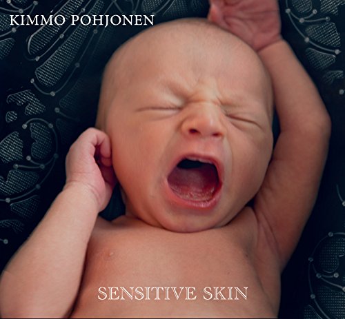 CD cover: close-up of a crying baby against a dark, patterned background.