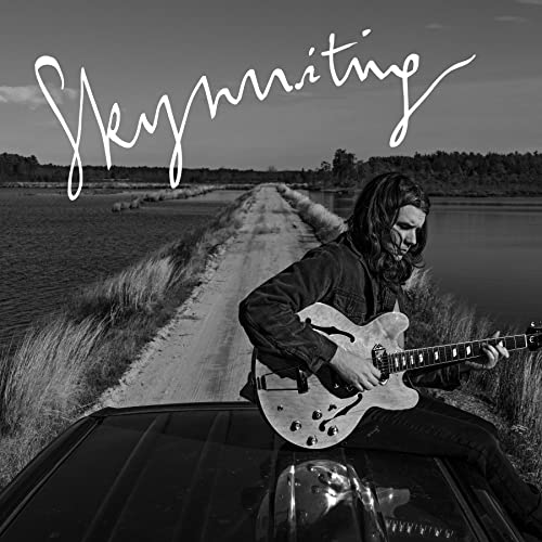 Black and white album cover featuring a musician with a guitar.