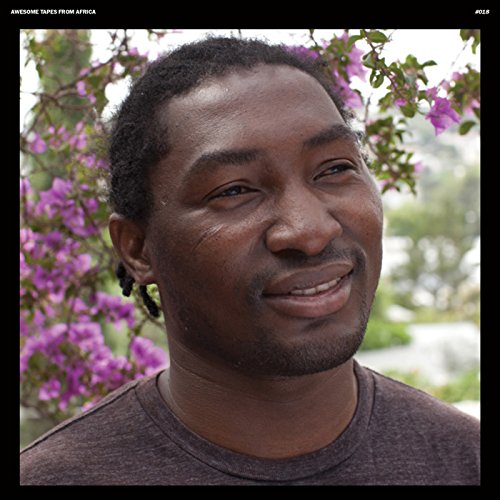 Portrait of S.k. Kakraba, a man with dreadlocks, smiling gently.