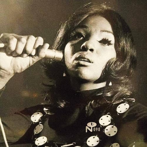 Black and white portrait of a woman singing into a microphone.