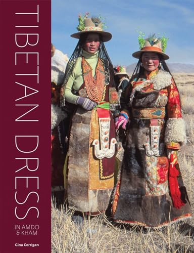 Two women in traditional Tibetan clothing and hats standing in a field.
