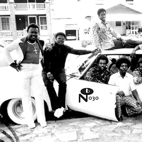 Black and white photo of a group of men posing with a car.