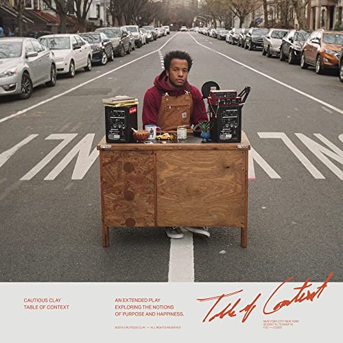 Album cover: man with music equipment on a street corner.