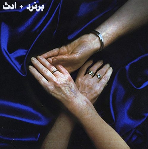 Hands with rings rest on blue fabric, album cover for "Jem.