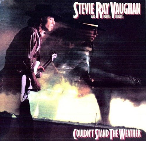 Stevie Ray Vaughan in a hat playing guitar with a blurry, stormy background effect.