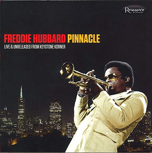 Freddie Hubbard playing trumpet against a night city skyline background.