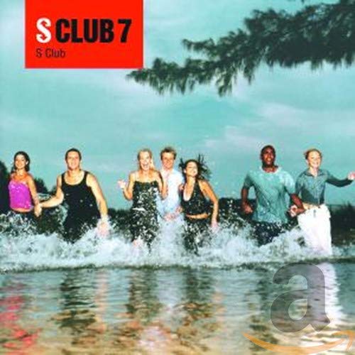 Seven people running through shallow water with a tree and cloudy sky behind them.